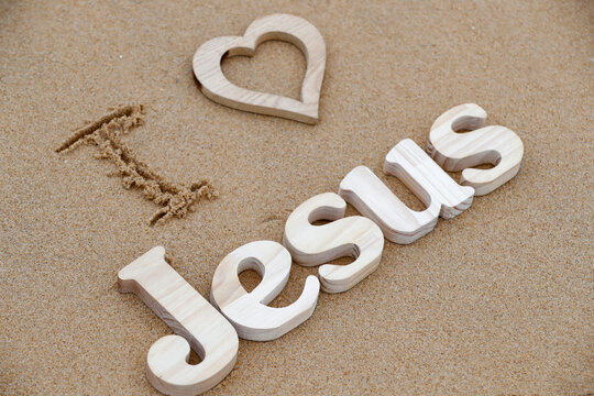 Wooden letters forming the word JESUS with heart on a background of beach sand, I love Jesus, Christian symbol, Vietnam, Indochina