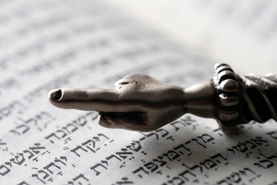 A silver Yad Jewish ritual pointer on a Torah, France