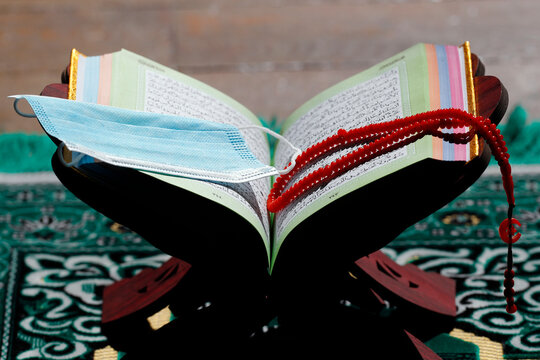 Coronavirus (COVID-19) epidemic, an open Holy Quran, Muslim prayer beads and a mask, France