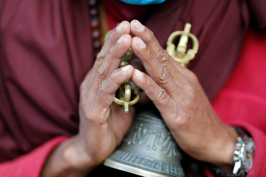 Buddhist monk (lama) in traditional robes holding ritual attributes of Buddhism, rosary, vajra, bell, Pema Osel Ling Monastery, Kathmandu, Nepal
