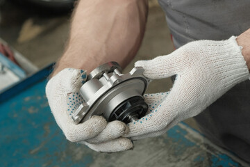 The water pump is new in the hands of an auto mechanic.Close-up.Compliance and serviceability...