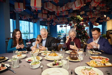Family using their gadgets during Christmas celebration