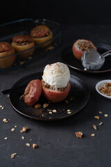 Baked apples with granola and ice cream. Apples on a dark background. Oatmeal in apples.