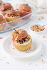 Baked apples with granola and ice cream. Apples on a dark background. Oatmeal in apples.