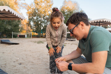 Father with child girl playing on the riverside, happy modern involved fatherhood. 