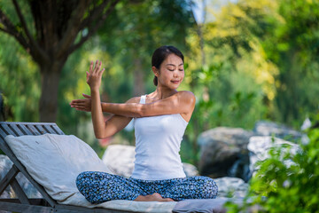 Young woman practicing yoga in the nature .Yoga is meditation and healthy sport concept relaxing with green nature background
