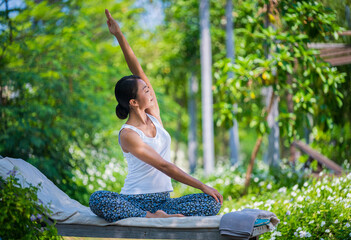 Young woman practicing yoga in the nature .Yoga is meditation and healthy sport concept relaxing with green nature background