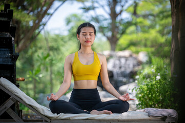 Young woman practicing yoga in the nature .Yoga is meditation and healthy sport concept relaxing with green nature background