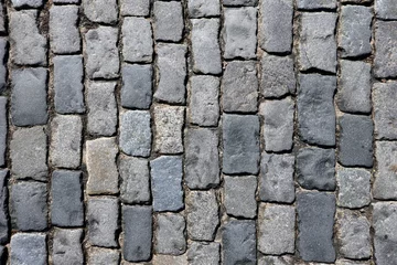 Gordijnen Dark grey cobblestone pavement from old smooth stones as background top view close up © DyMaxFoto