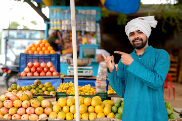 Young Indian fruit seller selling or showing his fruit