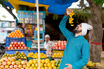 Young Indian fruit seller selling or showing his fruit