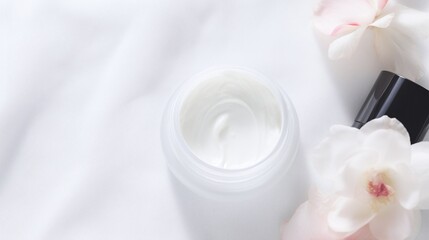 Obraz na płótnie Canvas Luxury Moisturizing Cream with Elegant White Flowers on Soft Silk Background for Beauty and Skincare Concept