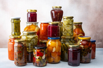 Preserving vegetables for the winter, a lot of glass jars with canned vegetables and adjika, jam...