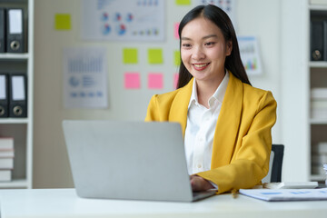 Cheerful businesswoman working with laptop in office, chatting Look at the laptop and talk about business, marketing, presentations video conference call meeting online training working in the office