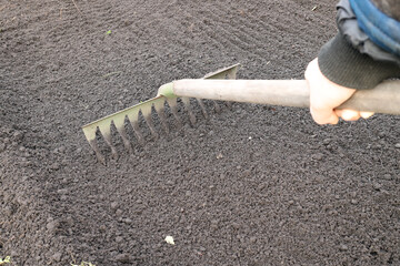 rake - a tool for loosening the soil. Hand holding a rake