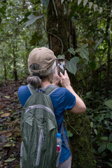 Woman taking a photo in a tropical forest