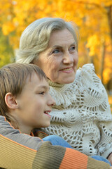 grandmother with boy in the autumn park