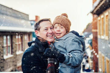 Father with little son having fun together outdoor on frosty day