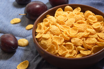 Bowl with cornflakes and fruits on the table, close-up