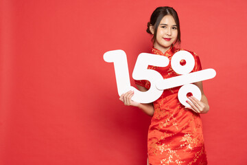 Young Asian woman wearing golden traditional cheongsam qipao dress showing 15% number or fifteen...