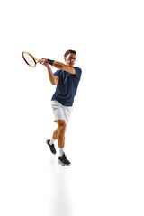 Competitive man in his 30s, tennis player in motion, hitting ball with racket, practicing isolated over white background. Concept of professional sport, competition, game, math, hobby, action