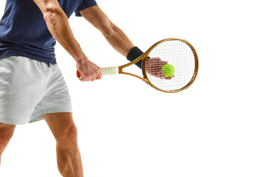 Cropped image of male tennis player in blue shirt and white shorts, serving ball with racket isolated over white background. Concept of professional sport, competition, game, math, hobby, action