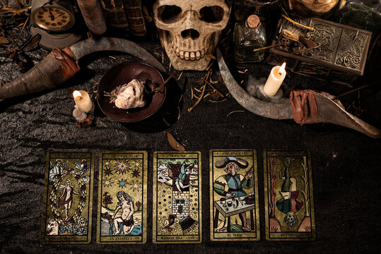 Un espacio m&iacute;stico con artefactos m&aacute;gicos como una calavera, libros antiguos y cartas de tarot, reflejando la intriga y el misterio de antiguas pr&aacute;cticas de brujer&iacute;a