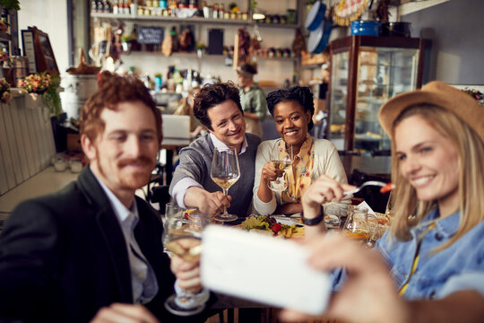 Friends eating in restaurant taking selfie