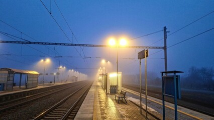 Night railway terminal. Deserted train station in fog. Concept of travelling, tourism or commuting...