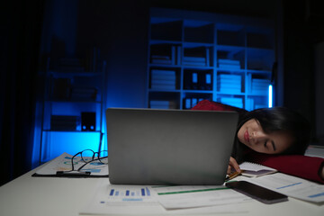 Exhausted Asian businessman working at his desk late at night