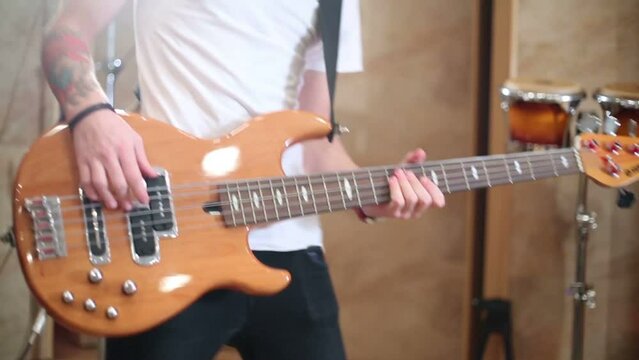 Hands of guitarist in white shirt playing guitar in studio