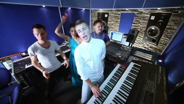 Musical group dance and sing in recording studio