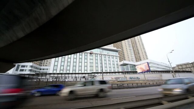 Moving under road junction bridge against residential apartments.