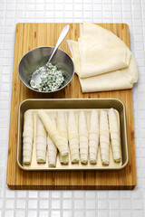 making Sigara borek, Cigar-like Turkish spring rolls.
A dough sheet called yufka wrapped with cheese filling and fried.