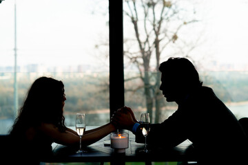couple in love on a date holding hands in a restaurant concept of love and support romance