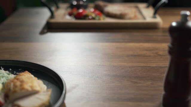 Female hands cutting fried fish on plate, close-up. Unrecognizable woman eating tasty delicious baked perch in restaurant. Keto diet