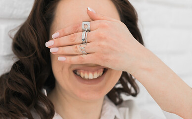 Women Jewelry concept. Woman's hands close up wearing rings and necklace modern accessories elegant...