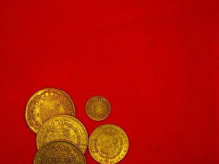 Spanish gold and silver coins, Shields and Reales, on a red background - obrazy, fototapety, plakaty