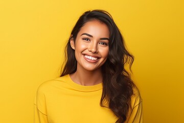 Cheerful Young Hispanic Woman Smiling on Vibrant Yellow Background - obrazy, fototapety, plakaty