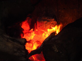 Yellow and orange flames over the embers of a winter bonfire