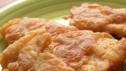 Golden Fried Fish on Green Plate. Close-up, shallow dof.