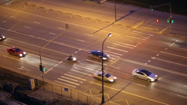 Night highway, cars cross zebra on green sign of traffic lights