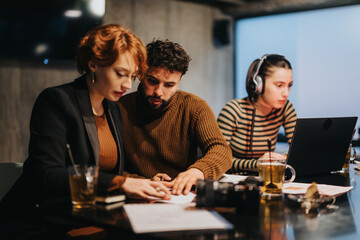 Business people working late at night in a corporate office. Collaboration, project planning, market research, and data analysis. Growing business, increasing revenue, successful team.