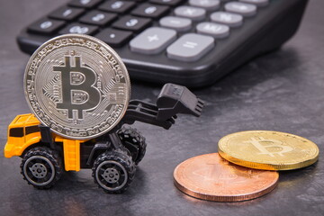 Bitcoins, miniature excavator and calculator. Cryptocurrency and international network payment. Finance concept