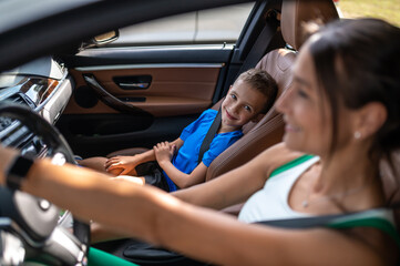 Mom and son sitting in the car and looking happy