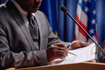 African American politician reading report in microphone at international conference