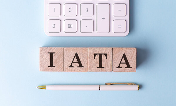 IATA on wooden cubes with pen and calculator, financial concept