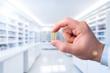 Human hand holding pill with fingers