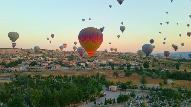 Aerial video. Captured against the canvas of the Cappadocian sky, this video showcases the enchanting spectacle of a hot air balloon festival. The vibrant balloons rise gracefully over the valleys of