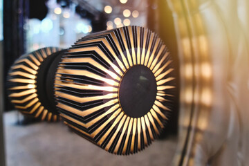 Close-up contemporary wall lamp installed in a mirror in a luxurious golden light hall interior.